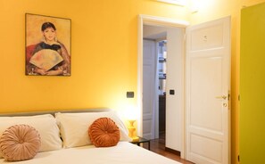 A hotel room with a bed, a painting on the wall, a door, and a hallway. - Roma, Castelfidardo House (Roma)