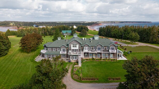Et stort, flerlænget hus med en rummelig forhave, en indkørsel og havudsigt.