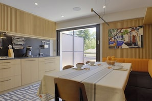 Enjoy meals with a view at this kitchen, featuring a dining table for four and a sliding door to the outdoors.