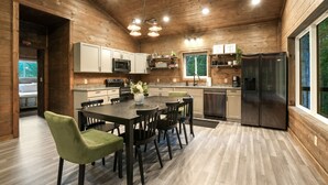 Una cocina moderna con paredes de madera, una isla central y un refrigerador empotrado.
