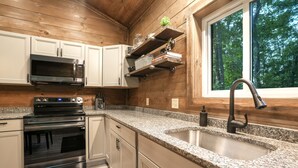 Eine moderne Küche mit Granit-Arbeitsplatten, Edelstahlgeräten und Holzvertäfelung.