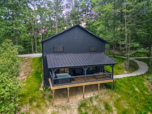 A two-story cabin with a covered deck and a hot tub. - Game Haven | Hocking Hills, Game Room, Hot Tub (McArthur)