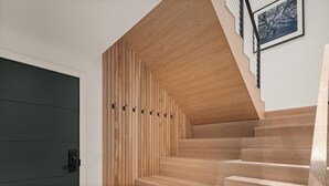 A modern staircase with wooden steps and a sloped ceiling. - Stowe Mt Resort | Spruce Peak | 4 Bed | Treehouse Condo | Sleeps 16 (Stowe)