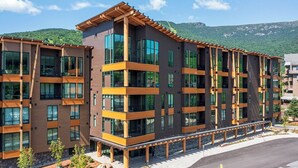 A multi-story hotel with a modern design, featuring balconies and large windows. - Stowe Mt Resort | Spruce Peak | 4 Bed | Treehouse Condo | Sleeps 16 (Stowe)