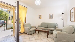 A living room with a sofa set, a coffee table, and a floor lamp. - Casa Catalpa near the beach (TORTOLI)