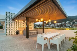 Relax and dine al fresco amidst the cityscape from this modern patio, complete with a long table and comfortable seating.