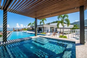 Relax by the pool surrounded by a pergola and lounge chairs.