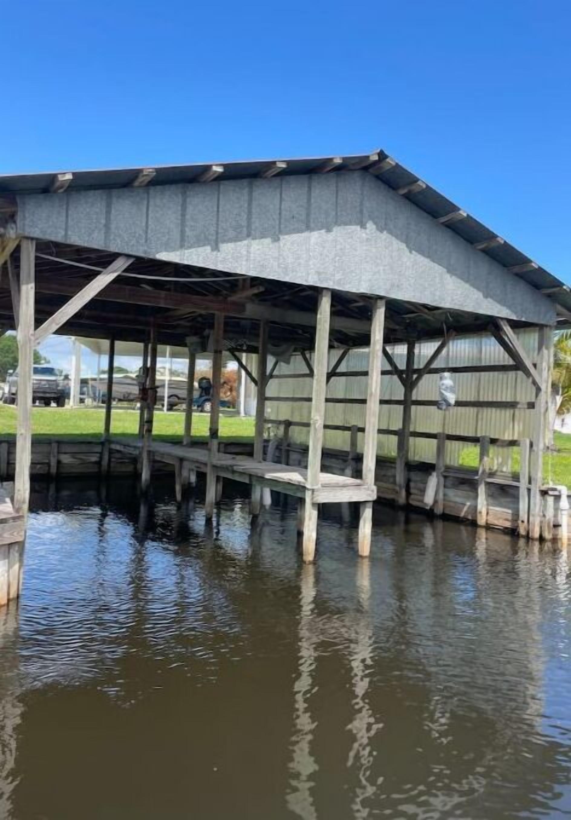 Een houten steiger die zich uitstrekt over het water, ondersteund door een metalen constructie met een dak.