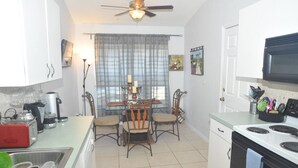 A compact kitchen with a dining table, chairs, a ceiling fan, a microwave, and a sink. - "NEW to MARKET" <br>Charming 3-Bedroom, 2-Bath Vacation Home in Quiet Gated Community (Davenport)