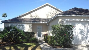 A single-story house with a front door, a garage, and a well-maintained lawn. - "NEW to MARKET" <br>Charming 3-Bedroom, 2-Bath Vacation Home in Quiet Gated Community (Davenport)