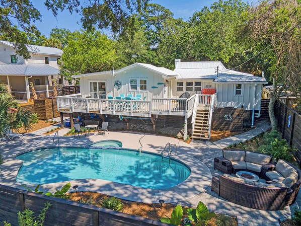 Ein Wohnhaus mit Schwimmbad, Außenbereich mit Sitzgelegenheiten und überdachter Terrasse.
