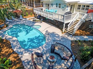 Ein Garten mit Pool, Gartenmöbeln und einer überdachten Terrasse.