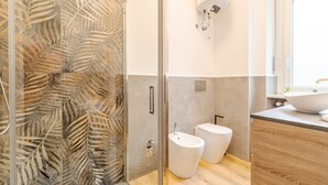 A modern bathroom with a glass shower enclosure, a bidet, and a sink with a large bowl. - Comfortable studio apartment that can comfortably accommodate up to 2 people. The accommodation is located in the quiet Parella district, a very green and well-served area: the MM Pozzo Strada stop is just 350m away and allows you to quickly reach the ce (Torino)