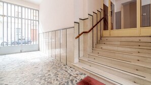A staircase with a wooden handrail, a tiled floor, and a glass railing. - Comfortable studio apartment that can comfortably accommodate up to 2 people. The accommodation is located in the quiet Parella district, a very green and well-served area: the MM Pozzo Strada stop is just 350m away and allows you to quickly reach the ce (Torino)
