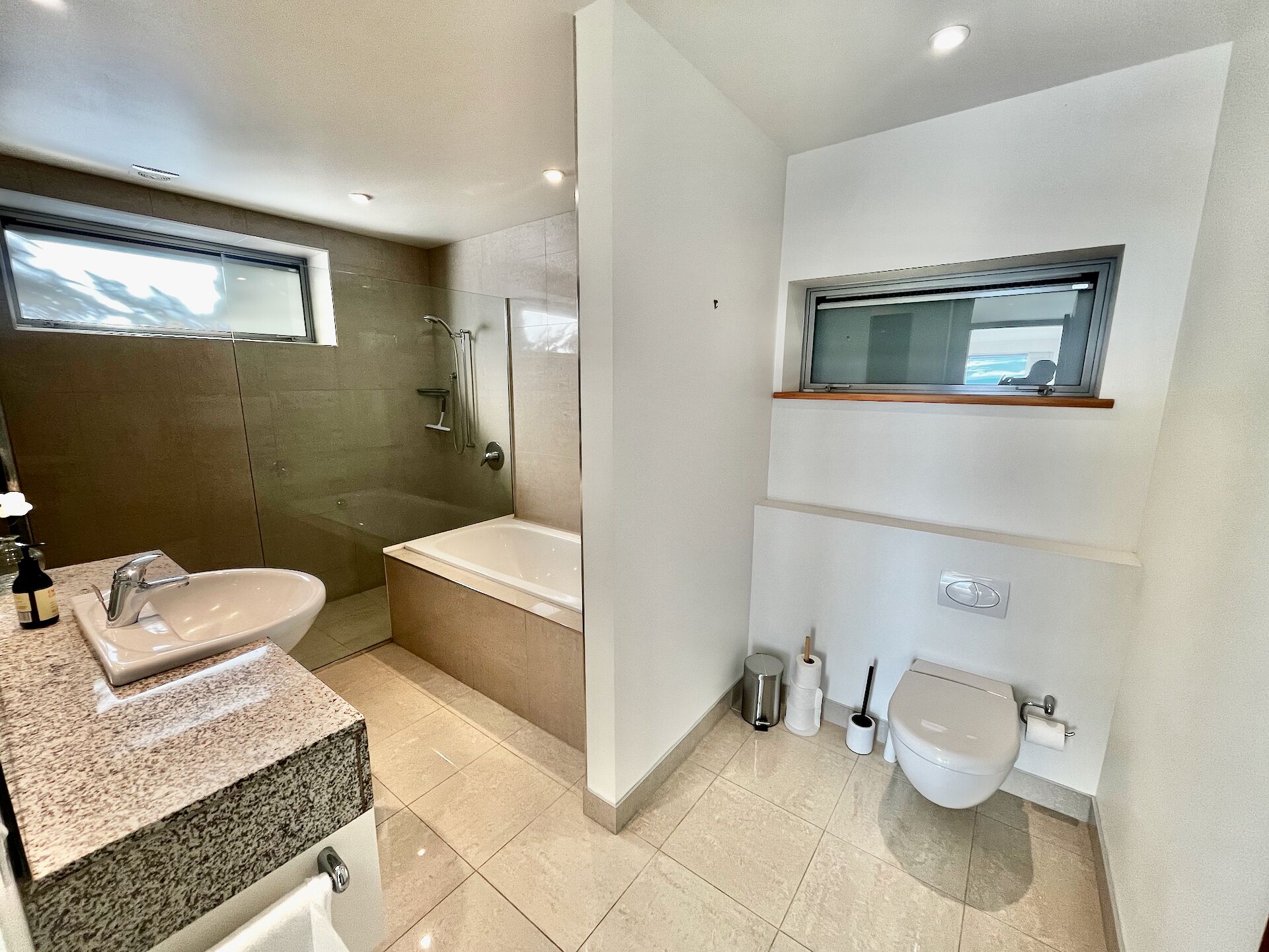 Une salle de bain moderne avec un lavabo, une baignoire et des toilettes.