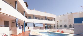 Apartment with pool near the beach and a park with sports facilities.