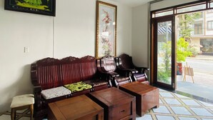 Una sala de estar con un sofá, dos sillones, una mesa de centro y un cuadro en la pared.