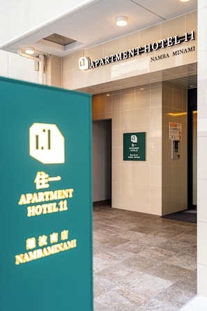 A hotel entrance with a sign for 'APARTMENT HOTEL 11' and 'NAMBA MINAMI'. - Apartment Hotel 11 Namba Minami (Osaka)