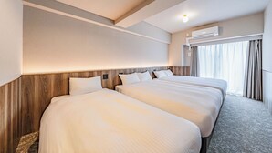 Habitación de hotel con dos camas, cabecero de madera, equipo de aire acondicionado y ventana con cortinas.