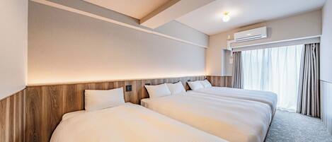 A hotel room with two beds, a wooden headboard, an air conditioning unit, and a window with curtains.