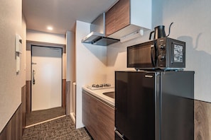 A compact kitchen with a microwave, refrigerator, and stove. - Apartment Hotel 11 Namba Minami (Osaka)