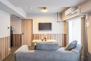 A modern hotel room with a bed, a small table with a vase, and a wall-mounted TV. - Apartment Hotel 11 Namba Minami (Osaka)