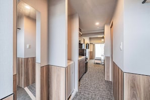A corridor with wooden paneling and a kitchenette area with a refrigerator and microwave. - Apartment Hotel 11 Namba Minami (Osaka)