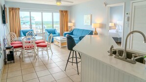 Ein Hotelzimmer mit Balkon, Essbereich, Küchenzeile und einem Bett.