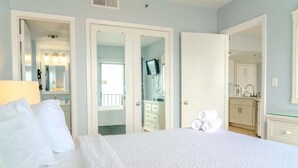 Ein Hotelzimmer mit Bett, einem Badezimmer mit Spiegel und Waschbecken sowie einer Küchenzeile.