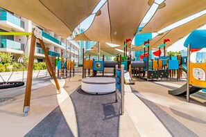 Children can play on the swing set, slide, and climbing wall in this outdoor play area.