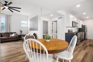 A modern kitchen with white cabinets, a microwave, and a refrigerator.