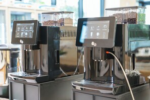 Una màquina de cafè amb pantalla digital i un recipient per a cafè en gra.