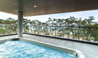 Una piscina en la azotea con vistas a una playa y árboles.
