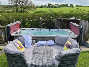Relax in the hot tub surrounded by a serene natural setting.
