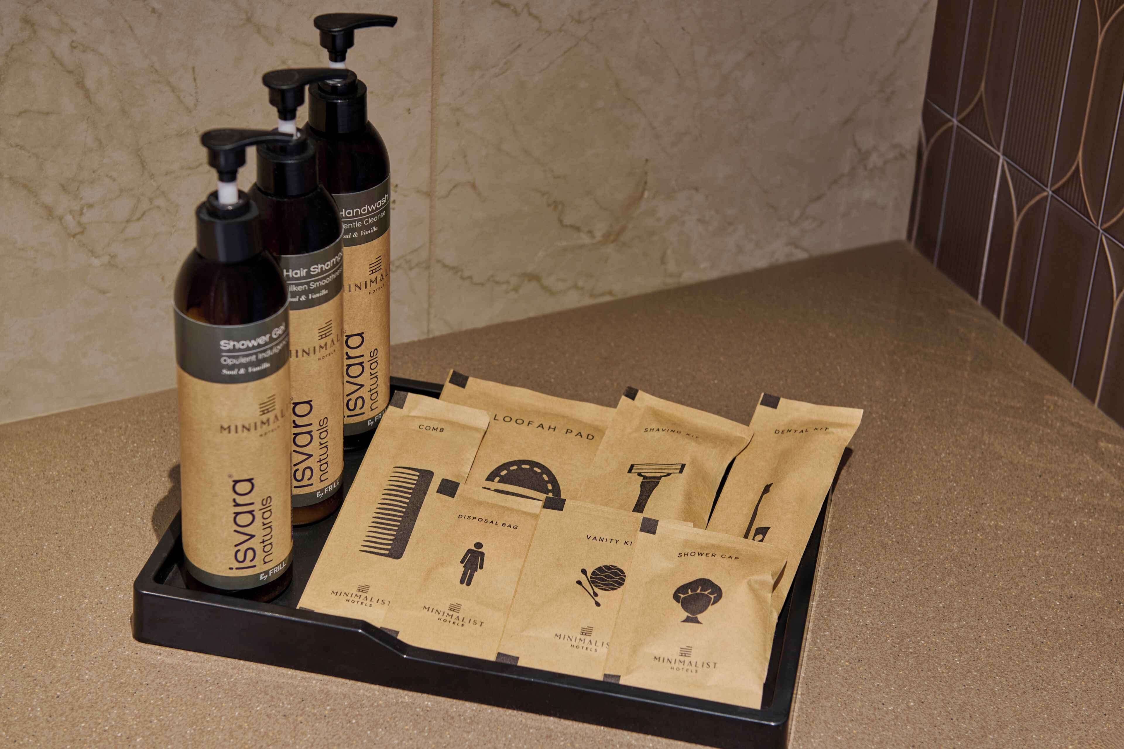 A bathroom counter with toiletries and a tray of disposable bags.