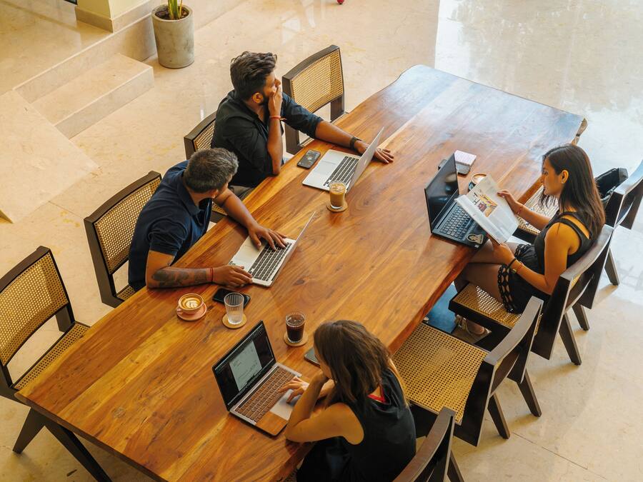 Une salle de conférence équipée d’une table en bois, de chaises et d’ordinateurs portables.