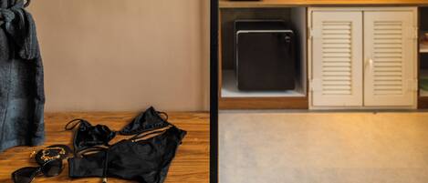 A room with a wooden vanity, a robe, a bag, and a small table with sunglasses.