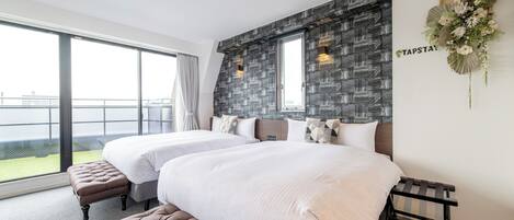 A modern hotel room with two beds, a large window, and a balcony.