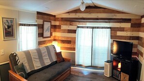 A cozy living room with a sofa, a television, and a fireplace.
