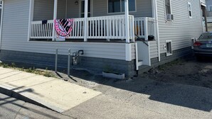 Uma casa de dois andares com varanda, alpendre e garagem.