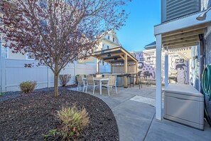 Enjoy al fresco dining under a shaded pergola with a garden view.