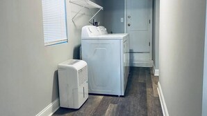 A laundry room with a dryer, washing machine, and a vent hood. - Beach Tower boardwalk walkout (Atlantic City)