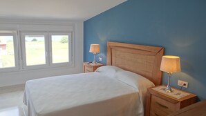 A bedroom with a large bed, two bedside tables with lamps, and a window with a view of the outdoors. - House in Lira near the beach (Sofan (Santa Maria De Lira-Carnota))