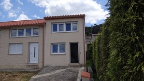 A two-story building with a beige facade, multiple windows, and a door. - House in Lira near the beach (Sofan (Santa Maria De Lira-Carnota))