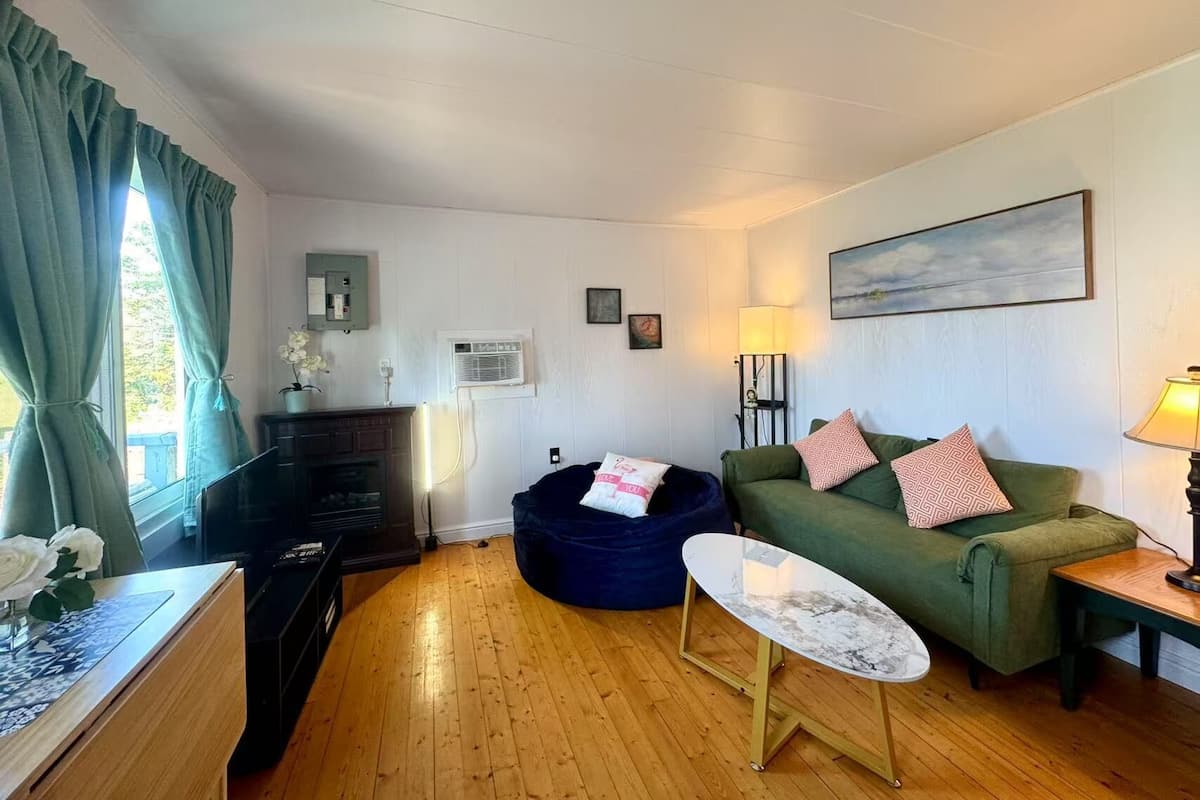 Design huis, uitzicht op baai, tuin | Woonruimte | Een 60-cm flatscreentelevisie met kabelzenders en een open haard