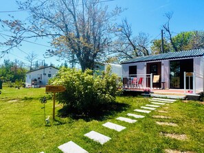 A white building with a porch and a sign indicating an office. - Skyline Terrace Cottages (Stanhope)