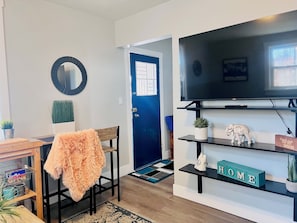 Relax in this stylish living room with a large flat-screen TV, cozy coffee table, and a touch of greenery.