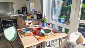 Et moderne køkken med spiseplads, udsigt til haven og et hyggeligt opholdsområde.