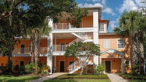 A multi-story building with balconies, a central staircase, and a covered entrance. - Davenport Andros Condo Retreat (Davenport)