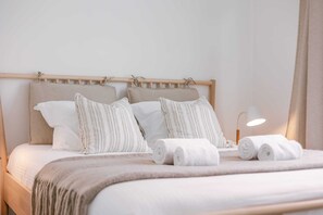 Restful retreat with a neatly made bed, bedside lamp, and plush pillows.